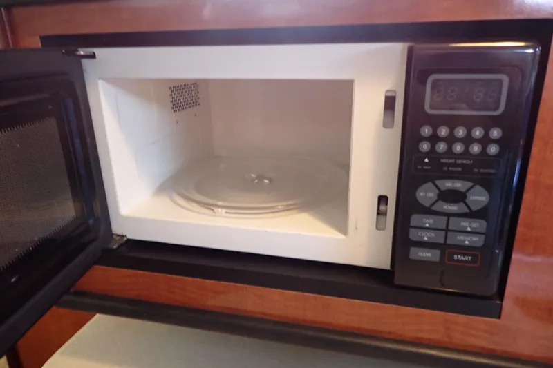 Slide: The Image of Microwave oven inside 2005 Sea Ray Sundancer 260 boat, door open, control panel visible. - 60