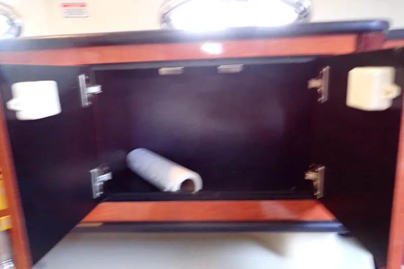 Slide: The Image of Open cabinet with paper towel roll inside on 2005 Sea Ray Sundancer 260 boat. - 64