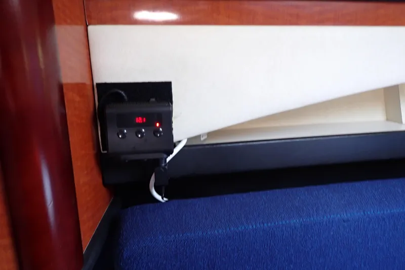 Slide: The Image of Control panel inside 2005 Sea Ray Sundancer 260 boat cabin, featuring digital display and buttons. - 65