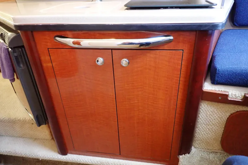 Slide: The Image of Wooden cabinet with chrome handle inside a 2005 Sea Ray Sundancer 260 boat interior. - 66