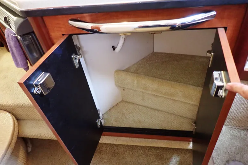 Slide: The Image of Open cabinet in 2005 Sea Ray Sundancer 260 boat interior, revealing carpeted storage space. - 67
