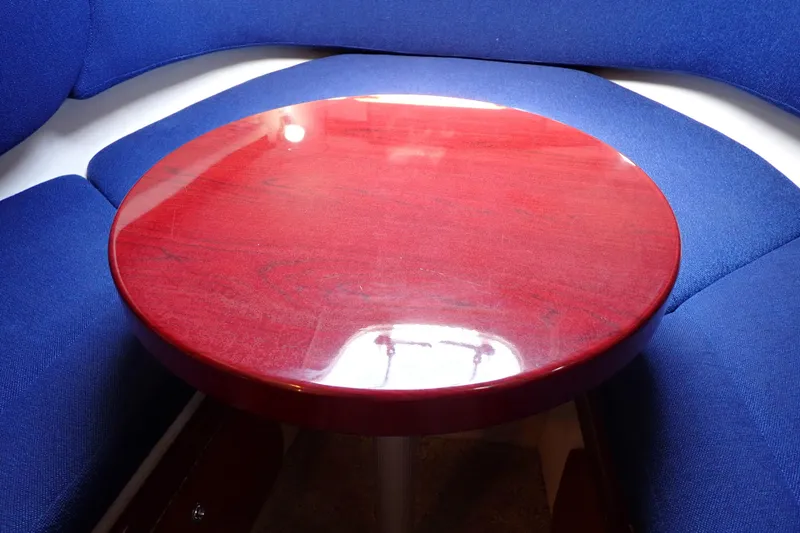 Slide: The Image of Interior of 2005 Sea Ray Sundancer 260 with round wooden table and blue seating. - 69