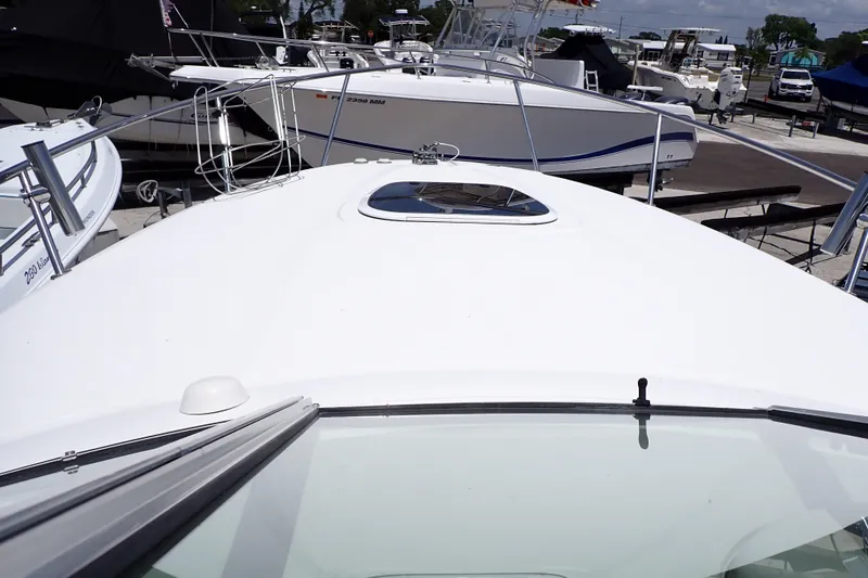 Slide: The Image of 2005 Sea Ray Sundancer 260 boat deck view at marina, surrounded by other vessels. - 8