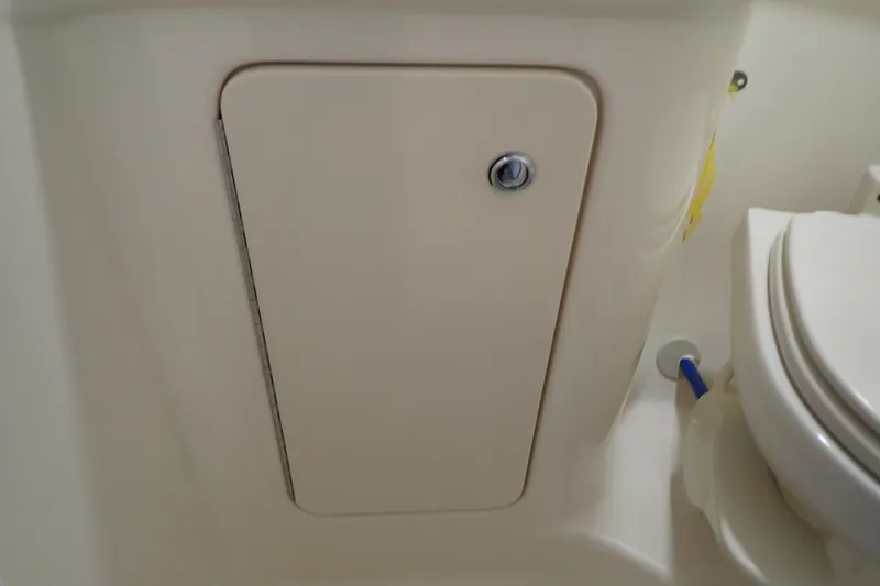 Slide: The Image of 2005 Sea Ray Sundancer 260 bathroom compartment with storage door and toilet. - 84