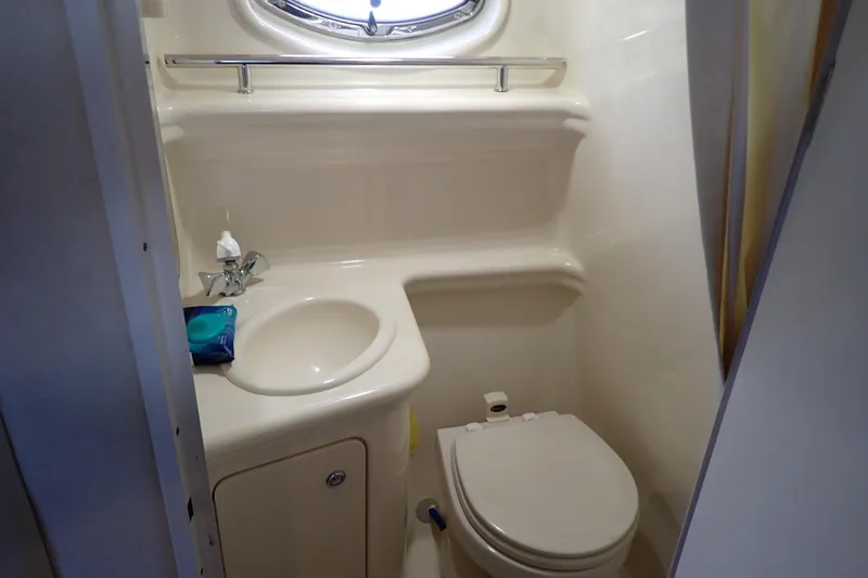 Slide: The Image of Compact bathroom in 2005 Sea Ray Sundancer 260 boat, featuring sink and toilet. - 87