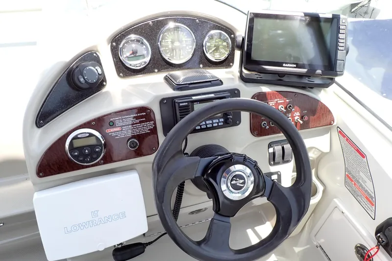 Slide: The Image of 2005 Sea Ray Sundancer 260 helm with steering wheel, gauges, and Garmin navigation system. - 9