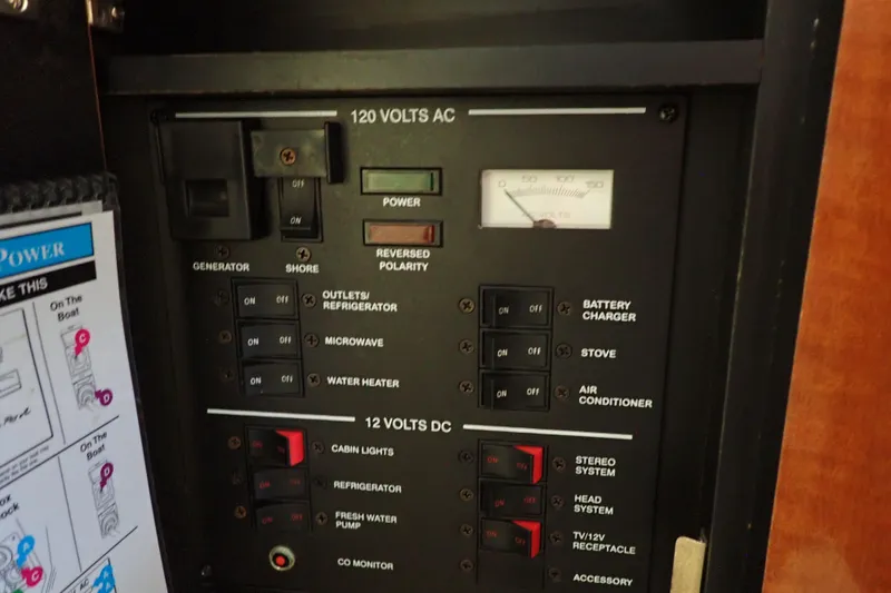 Slide: The Image of Electrical control panel of a 2005 Sea Ray Sundancer 260 boat, showing switches and voltmeter. - 92