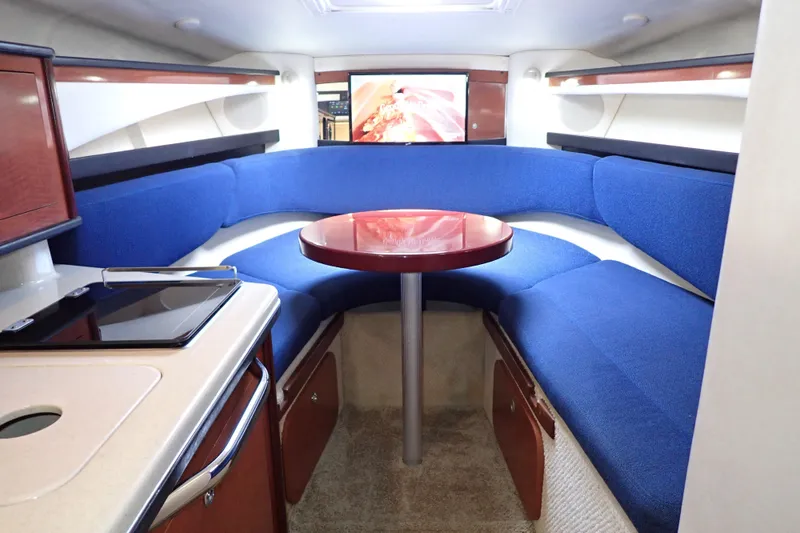 Slide: The Image of Interior of 2005 Sea Ray Sundancer 260 with blue seating and compact kitchenette. - 95