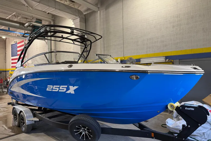 Slide: The Image of 2025 Yamaha Boats 255XD in a showroom, featuring a sleek blue design on a trailer. - 9