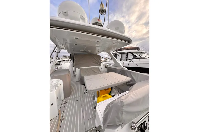 Slide: The Image of 2020 Azimut Verve 40 yacht deck with covered seating and table, docked at marina. - 24