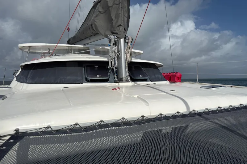 Slide: The Image of 1995 Fountaine Pajot Athena 38 catamaran on open water under cloudy skies. - 11