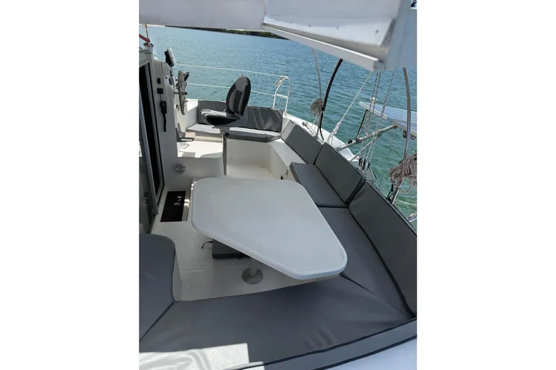 Slide: The Image of 1995 Fountaine Pajot Athena 38 catamaran cockpit with seating and table, overlooking water. - 14