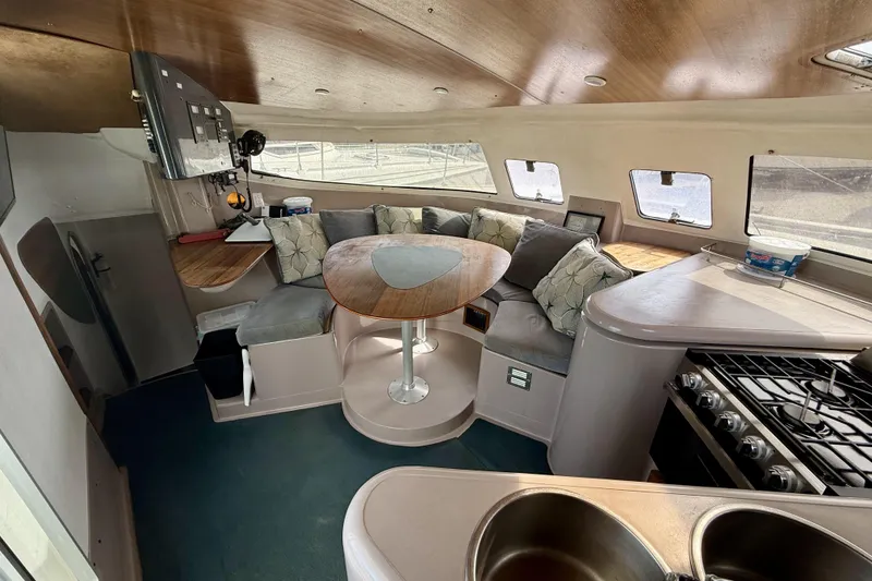 Slide: The Image of Interior of 1995 Fountaine Pajot Athena 38 catamaran with cozy seating and kitchen area. - 17