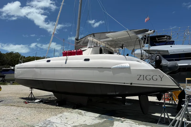 Slide: The Image of 1995 Fountaine Pajot Athena 38 catamaran "Ziggy" on land, under clear blue sky. - 2