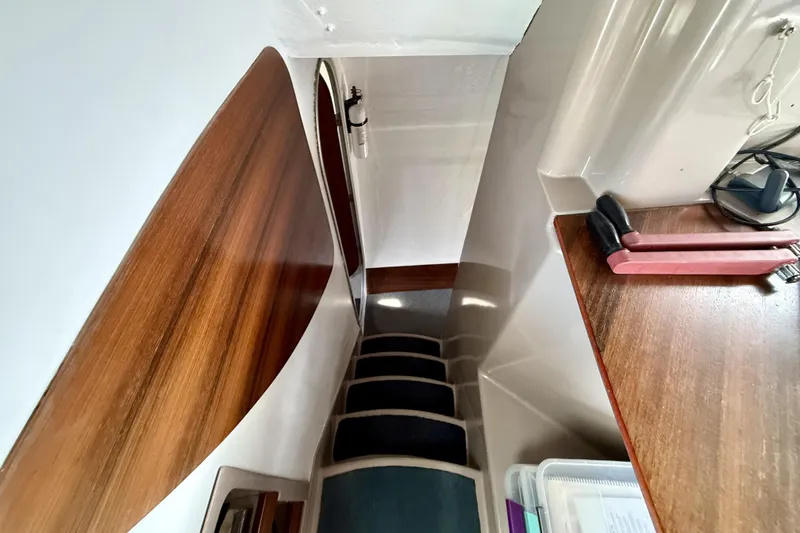Slide: The Image of Interior view of 1995 Fountaine Pajot Athena 38 yacht, featuring wooden stairs and sleek design. - 23