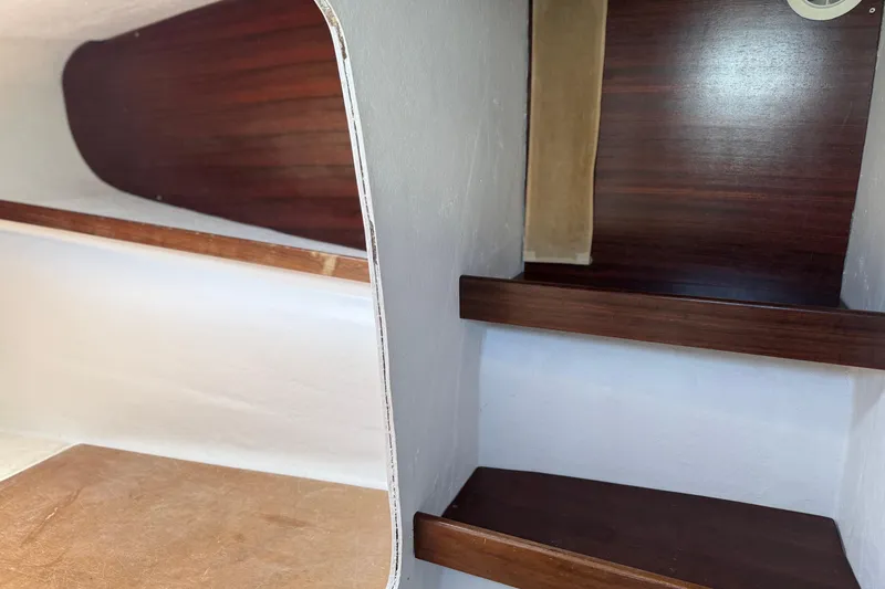 Slide: The Image of Interior view of a 1995 Fountaine Pajot Athena 38 catamaran with wooden shelves and white walls. - 25