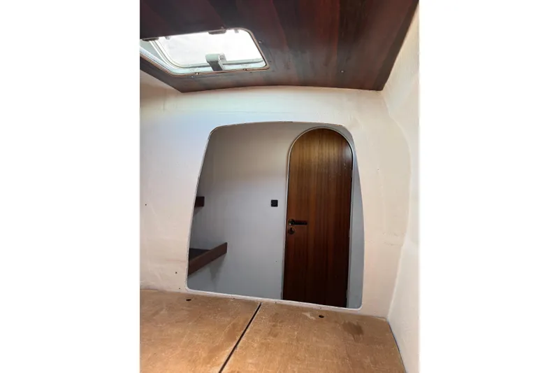 Slide: The Image of Interior view of a 1995 Fountaine Pajot Athena 38 catamaran, featuring a wooden door and ceiling hatch. - 26