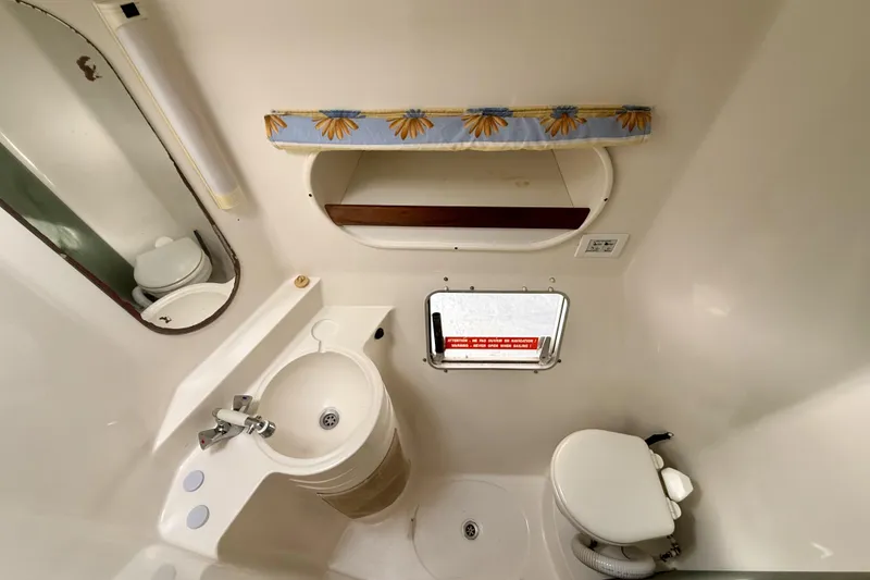 Slide: The Image of Bathroom interior of 1995 Fountaine Pajot Athena 38 catamaran, featuring sink, toilet, and mirror. - 28
