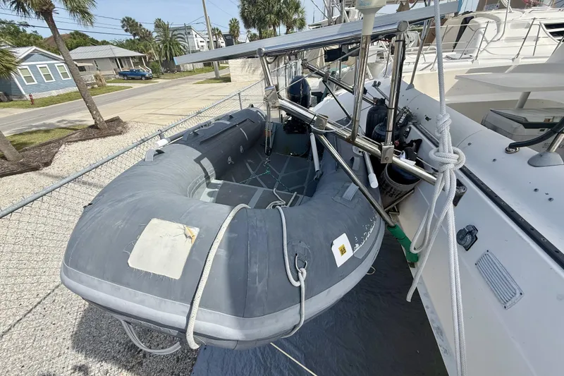 Slide: The Image of Inflatable dinghy on 1995 Fountaine Pajot Athena 38 catamaran, docked near palm trees. - 34