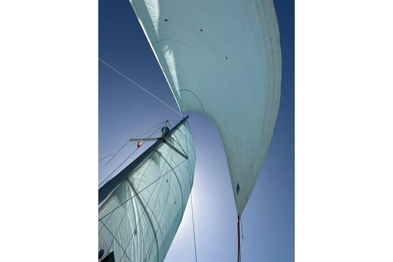Slide: The Image of Sails of a 1995 Fountaine Pajot Athena 38 catamaran against a clear blue sky. - 6