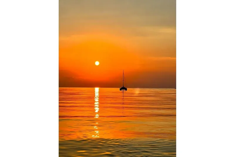 Slide: The Image of Sailboat silhouette at sunset on calm ocean, Fountaine Pajot Athena 38, 1995. - 7