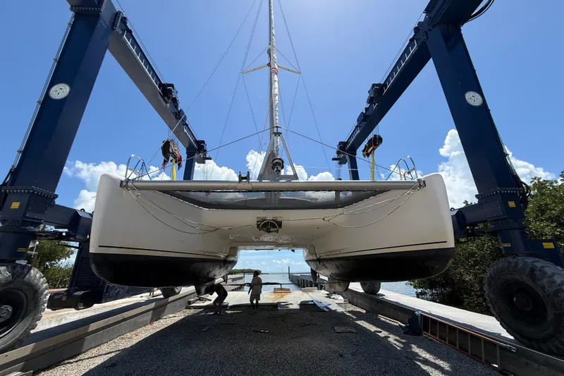 Slide: The Image of 1995 Fountaine Pajot Athena 38 catamaran lifted by crane, clear sky background. - 9
