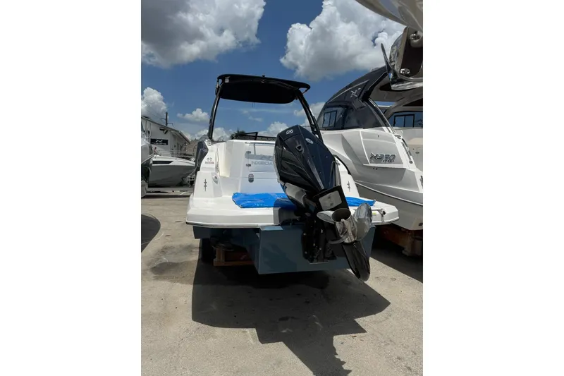 Slide: The Image of 2025 NX Boats NX270 with outboard motor, docked under a partly cloudy sky. - 10