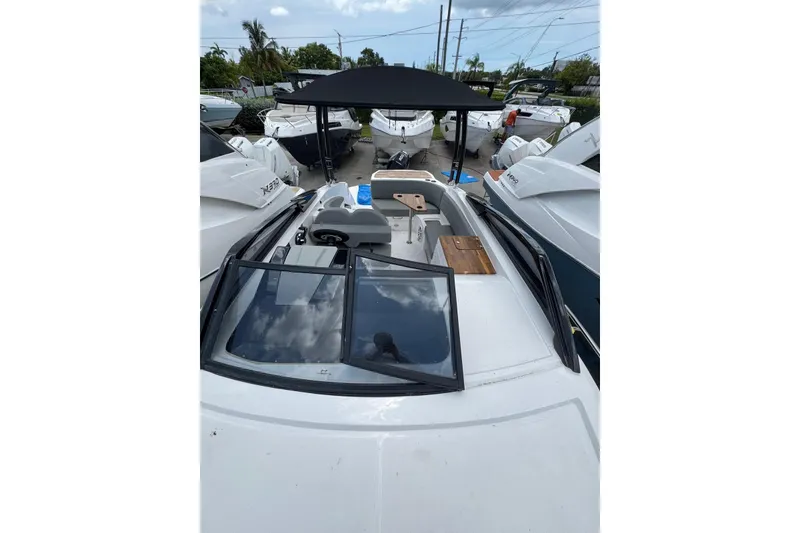 Slide: The Image of 2025 NX Boats NX270 with sleek design, spacious deck, and modern features in a marina setting. - 11