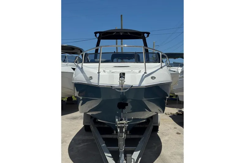 Slide: The Image of 2025 NX Boats NX270 on trailer, sleek design, ready for adventure under clear blue sky. - 18