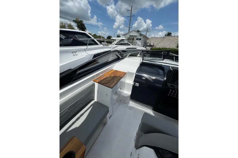 Slide: The Image of 2025 NX Boats NX270 interior with sleek seating and modern design under a sunny sky. - 19