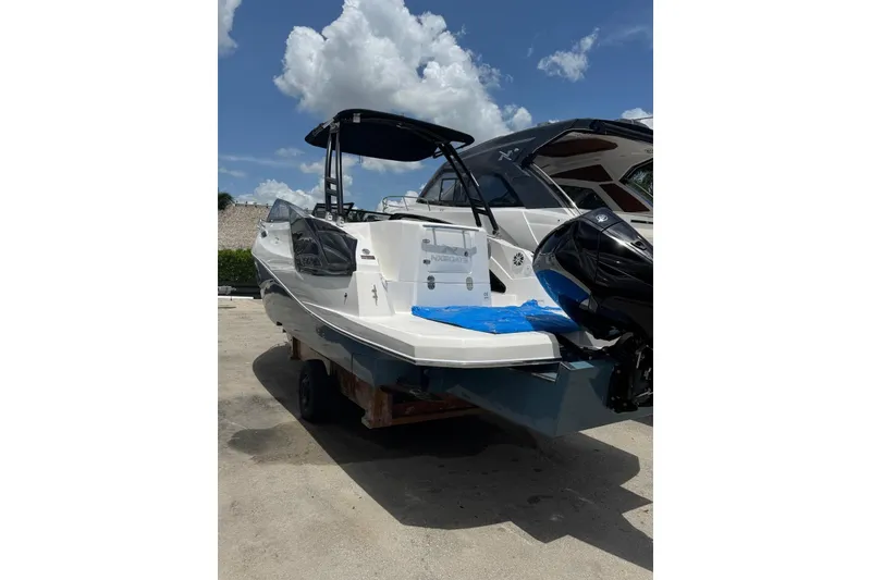 Slide: The Image of 2025 NX Boats NX270 on trailer under blue sky, showcasing sleek design and powerful engine. - 4
