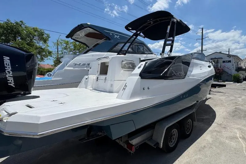 Slide: The Image of 2025 NX Boats NX270 on trailer, featuring sleek design and Mercury outboard motor. - 5