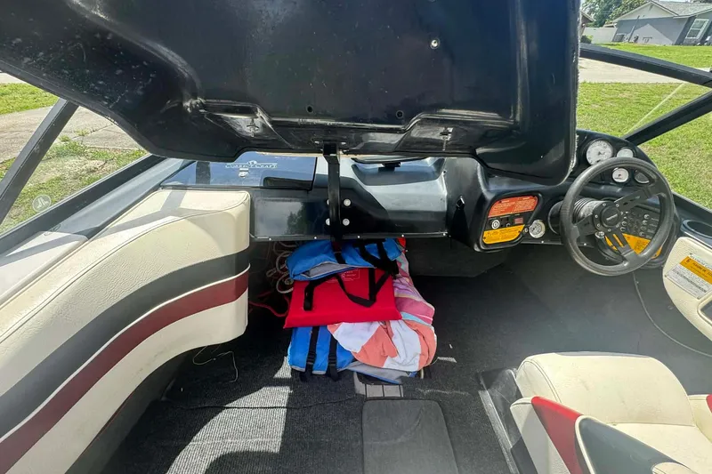 Slide: The Image of 1992 Nautique Ski Nautique 200 Closed Bow interior with open storage, steering wheel, and gauges. - 2