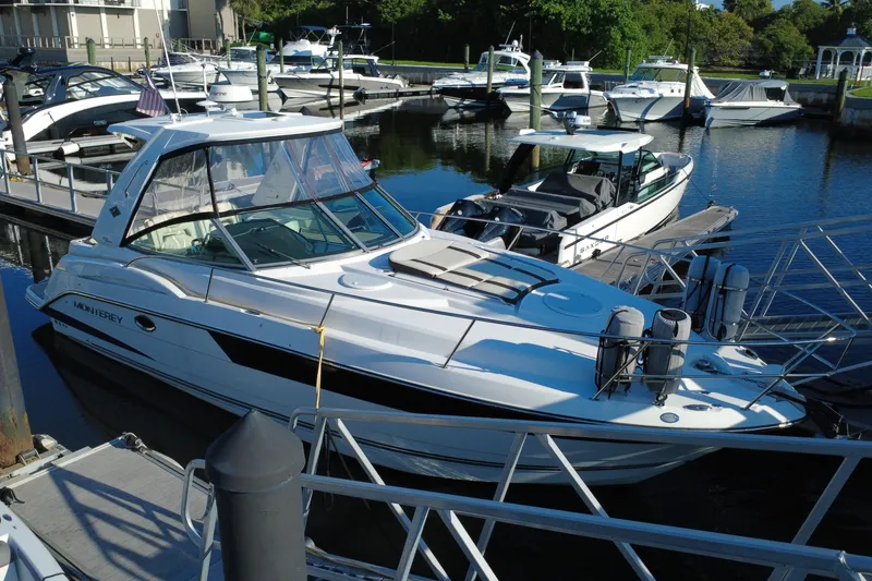 Slide: The Image of 2018 Monterey 355 Sport Yacht docked at marina, surrounded by other boats. - 2