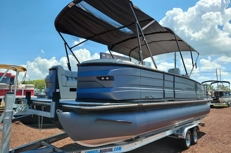 The Image of 2026 Starcraft RX 23 Q DH pontoon boat on trailer under blue sky. - 0