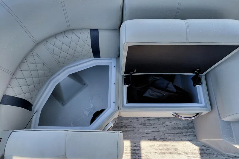 Slide: The Image of 2026 Starcraft RX 23 Q DH boat interior storage compartments with cushioned seating. - 15