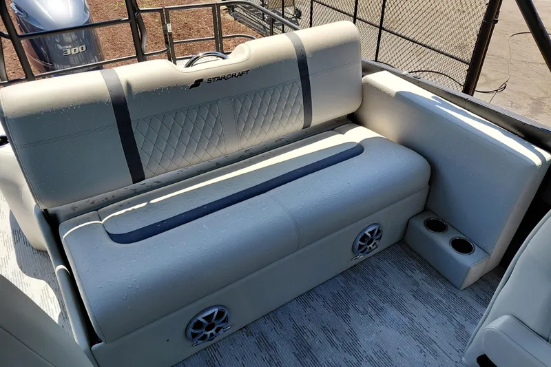 Slide: The Image of 2026 Starcraft RX 23 Q DH boat interior with cushioned seating and cup holders. - 24