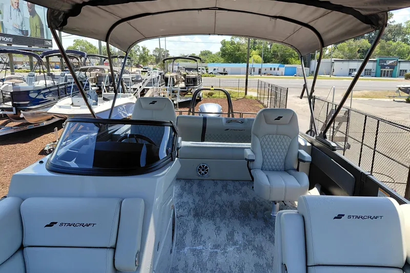 Slide: The Image of 2026 Starcraft RX 23 Q DH boat interior with seating and canopy at a dealership. - 34