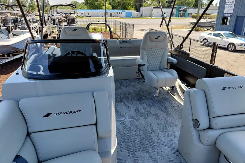 Slide: The Image of 2026 Starcraft RX 23 Q DH boat interior with modern seating and steering console. - 36