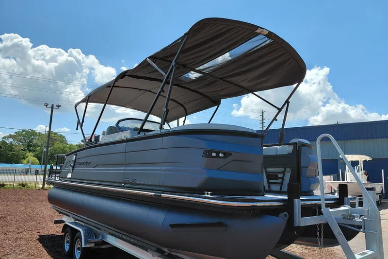 Slide: The Image of 2026 Starcraft RX 23 Q DH pontoon boat with canopy, displayed outdoors on a trailer. - 6