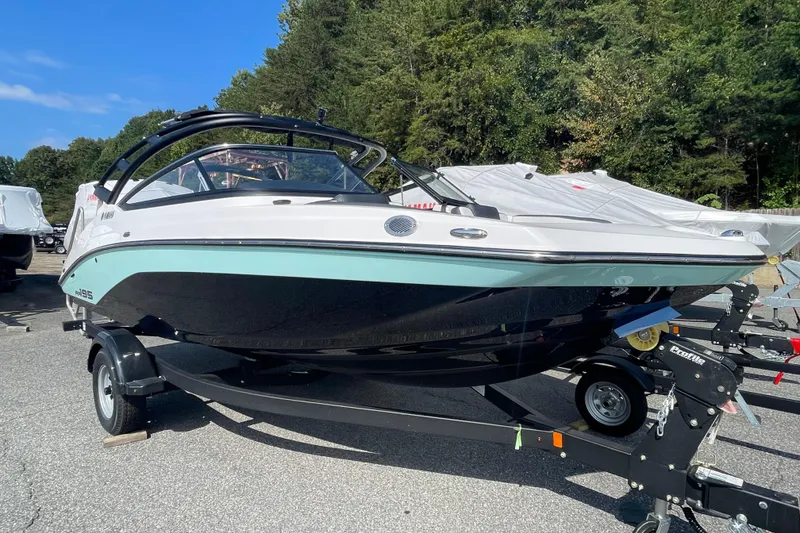 Slide: The Image of 2026 Yamaha Boats AR195 on trailer, parked outdoors with trees in background. - 3