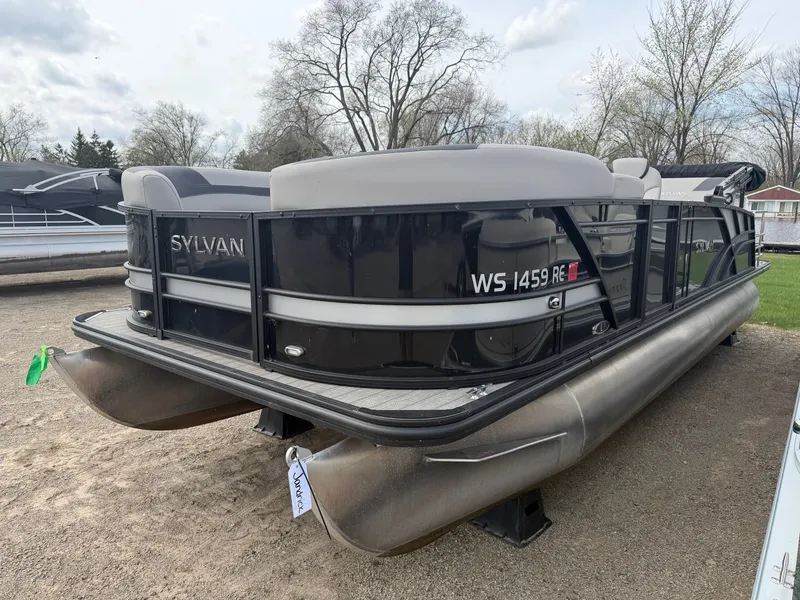Slide: The Image of 2022 Sylvan L3 RLZ pontoon boat parked on gravel. - 2