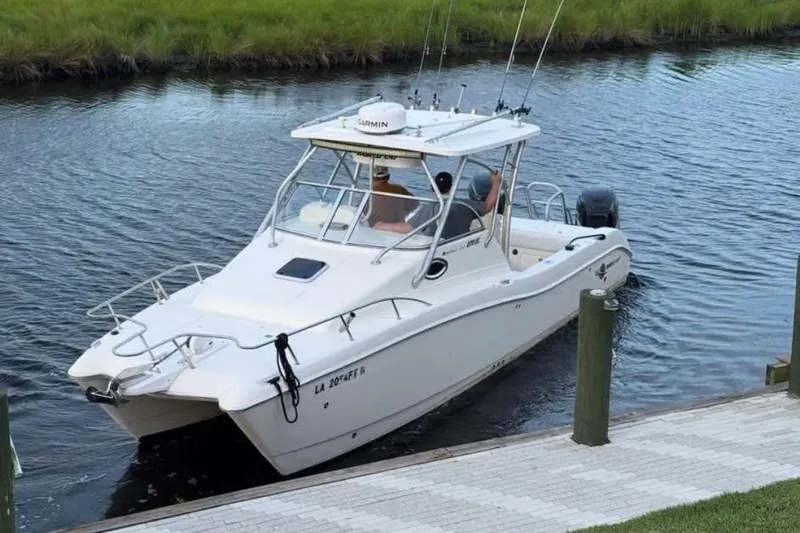 Slide: The Image of 2006 World Cat 270 EC boat docked on a calm waterway. - 3
