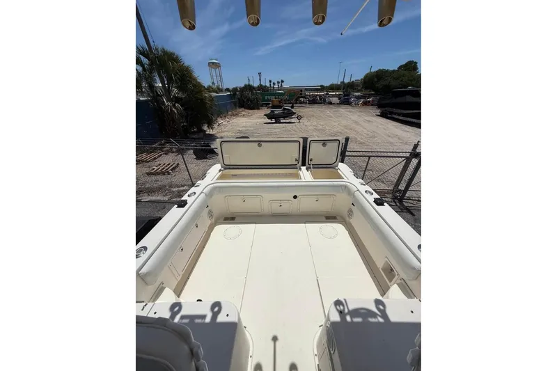 Slide: The Image of 2006 World Cat 270 EC boat deck with open storage compartments, parked outdoors. - 6