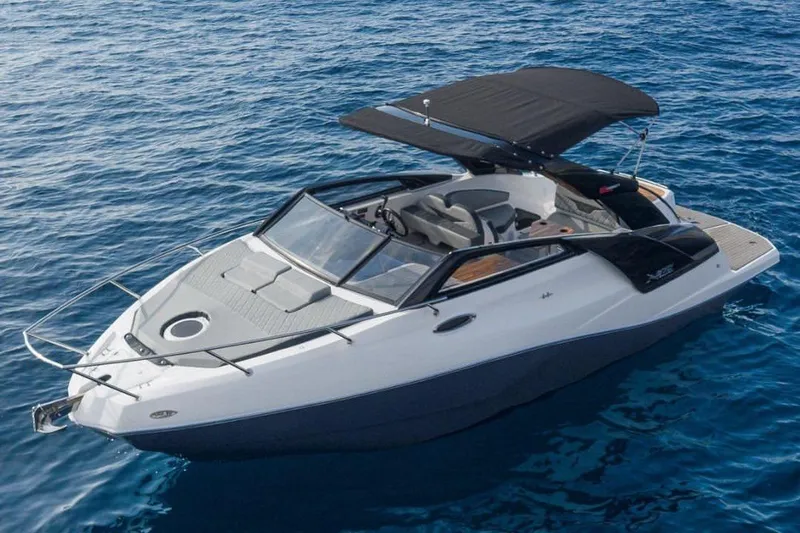 The Image of 2025 NX Boats NX270 cruising on clear blue water, featuring sleek design and sunshade. - 1