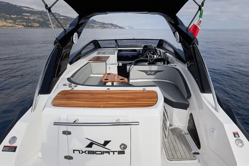 Slide: The Image of 2025 NX Boats NX270 luxury yacht interior with sleek design and wooden accents on open water. - 4