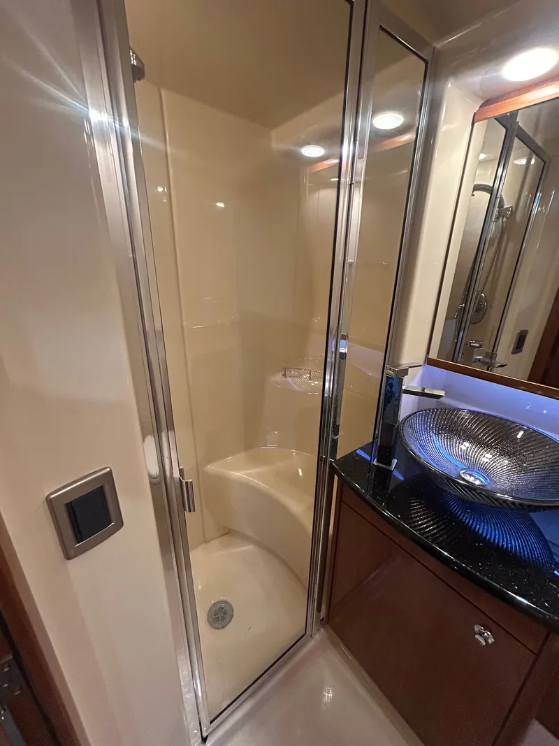 Slide: The Image of The image shows an elegant yacht bathroom with a glass shower enclosure and a modern sink. - 25