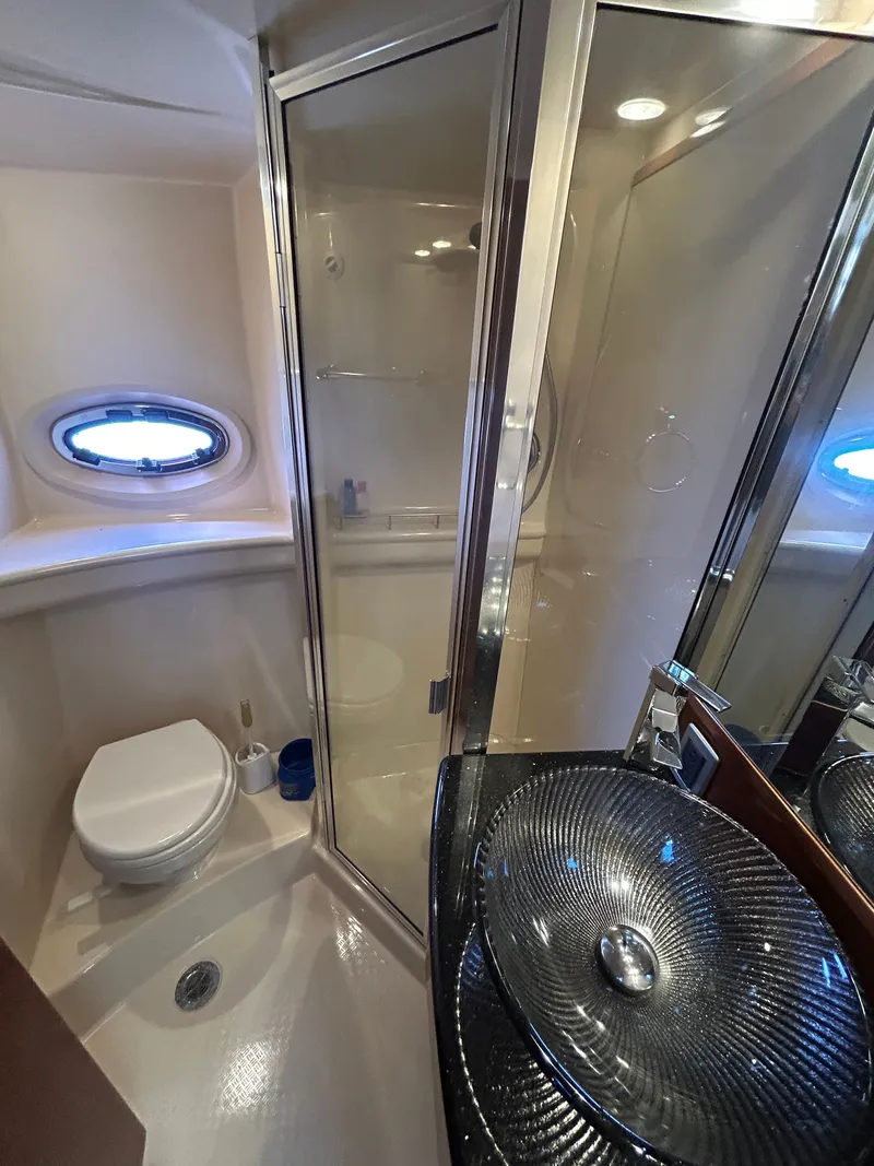 Slide: The Image of The image shows a yacht bathroom with a shower, sink, and porthole. - 32