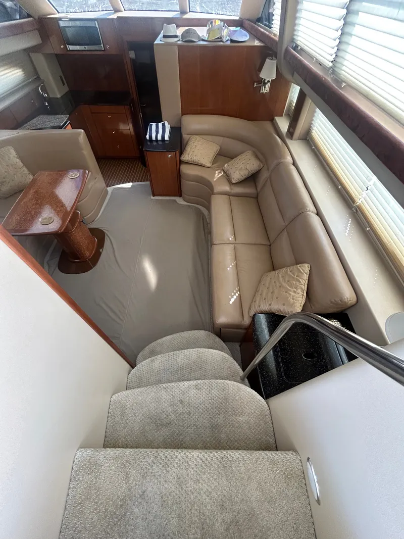 Slide: The Image of Interior of a 2007 Meridian 368 Motoryacht with beige sofa, wooden table, and stairs. - 18