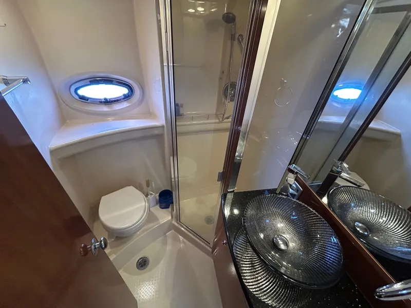 Slide: The Image of The image shows a yacht bathroom with a shower, sink, and porthole. - 31